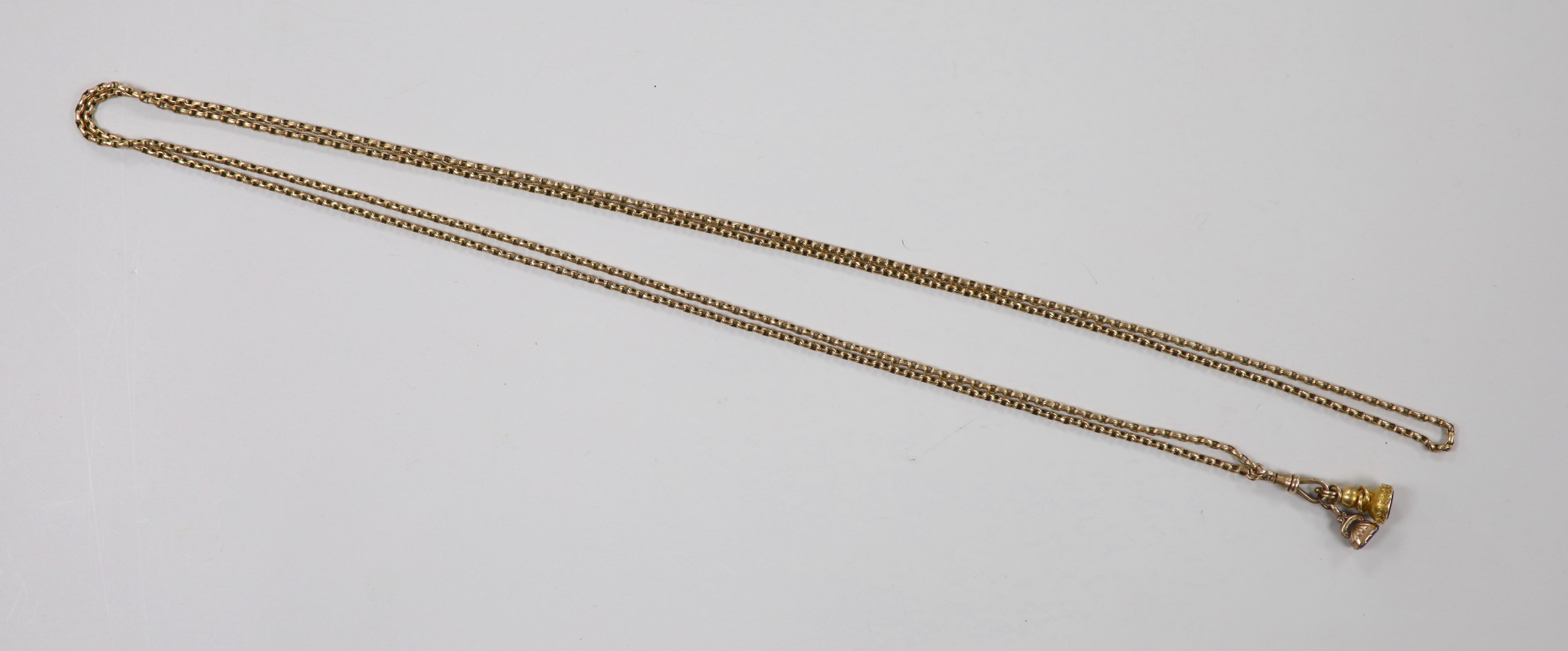 A late Victorian 9ct guard chain, hung with two yellow metal overlaid seals, with amethyst or red carnelian? carved matrices, chain length 164cm, 32.9 grams.